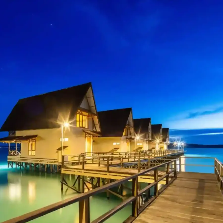 Over-water A-frame villas of Sienna Resort lit at dusk